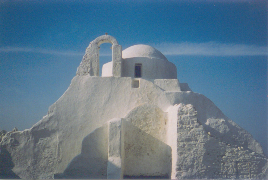 white church of paraportyiani in Mykonos town, next to a blue sky